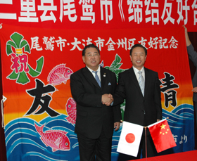 中国大連市金州区長と尾鷲市長の握手の写真